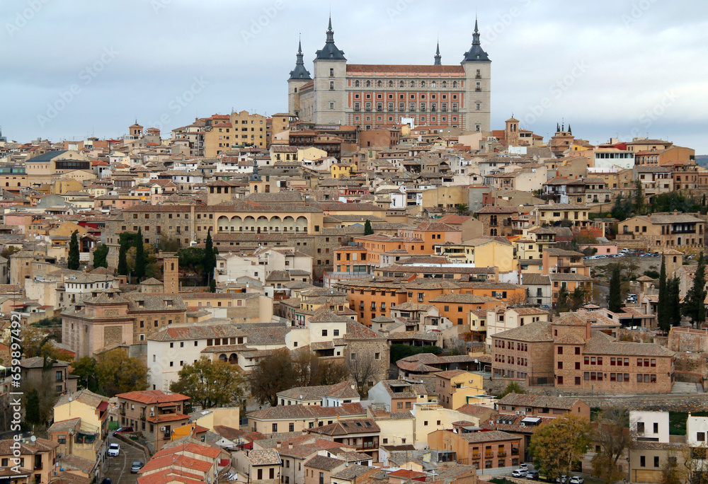 Panoramic view of the historic part of the city with the Alcazar de Toledo military museum building on the hill against a stormy sky in the city of Toledo, near Madrid, Spain