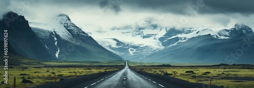 Stormy Icelandic road: Asphalt path leads to mountains under a brooding sky