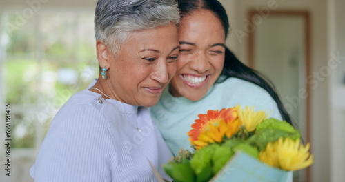Happy, mothers day and woman with flowers for surprise, gift and love for family, support and care in home. Wow, thank you and mom with floral, present and person giving parent a bouquet in house © Charlize D/peopleimages.com