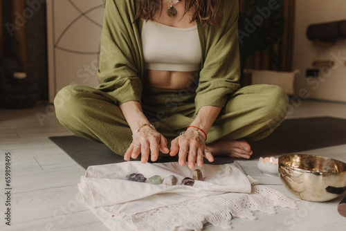 Fotografie Woman holds jewelry made of natural stones in her hand, her hands are decorated with rings and bracelets