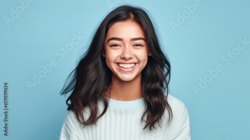 A portrait of a delighted young lady, her genuine smile illuminating the photo against a neutral studio backdrop.