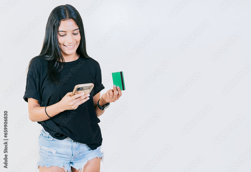 Girl holding credit card shopping online with cell phone isolated. People making online purchases with cell phones and credit cards isolated Girl holding credit card shopping online with cell phone isolated. People making online purchases with cell phones and credit cards isolated