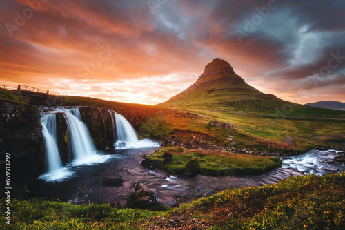 An epic sunset with Kirkjufellsfoss waterfall. Location Iceland, Europe.