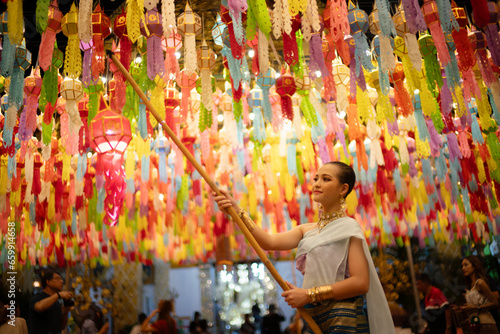 Beautiful Asian women holding a traditional paper lantern during Yi peng lantern festival at Wat Phra That Hariphunchai, Lamphun province, Thailand. photo