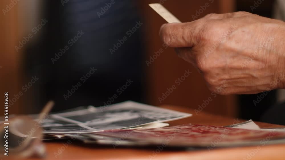 hands of an old man holding old family photos, home photo album, concept of nostalgia, family values, emotions of a pensioner, memory of the past hands of an old man holding old family photos, home photo album, concept of nostalgia, family values, emotions of a pensioner, memory of the past