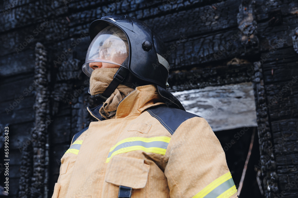 Fototapeta premium Firefighter officer man going to wooden house in fire. Concept rescue operation service.