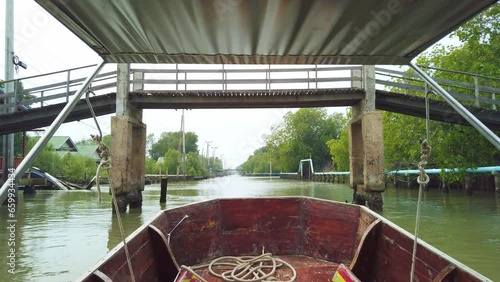 Take a traditional wooden long tail boat with beautiful scenery view of mangrove forest and local communities along the canal in Bangkok, Thailand, South East Asia. Board a traditional long tail boat.