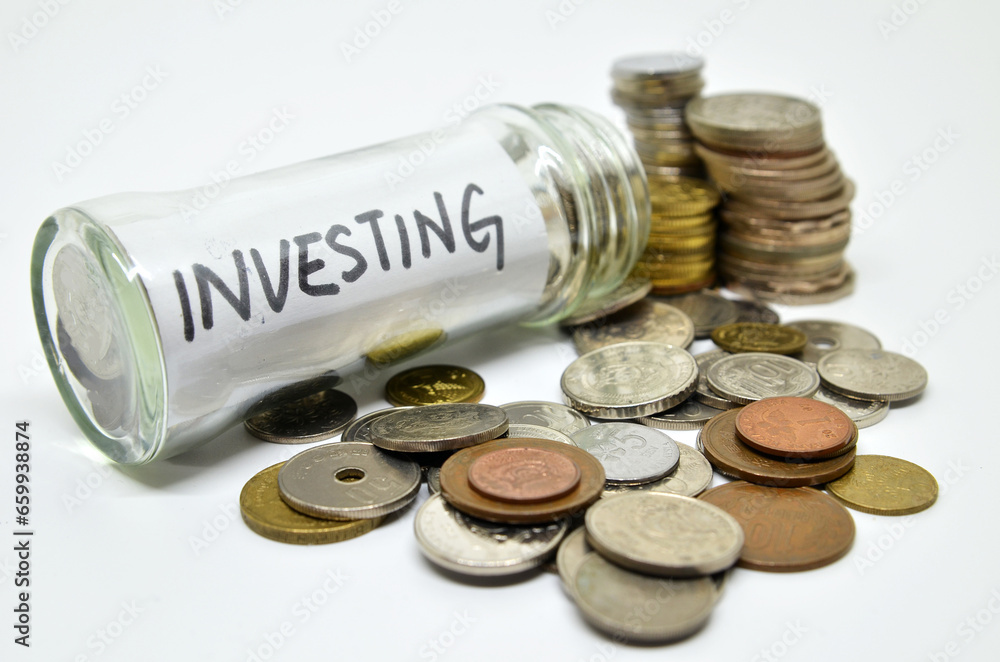 Investment lable in a glass jar with coins spilling out Investment lable in a glass jar with coins spilling out