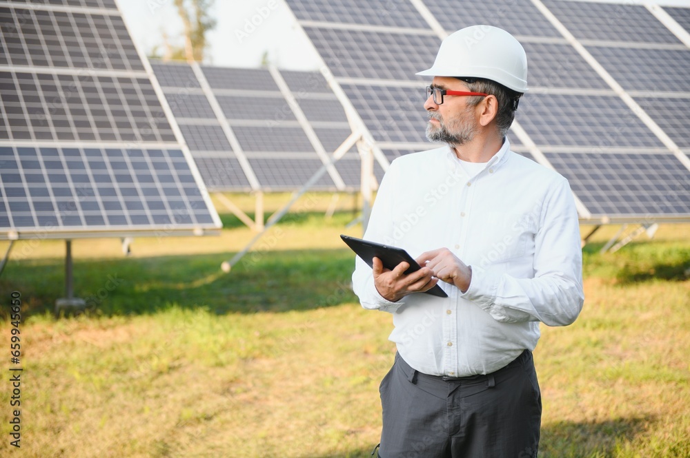 Senior male engineer inspects solar panels on farm. Clean energy. Senior male engineer inspects solar panels on farm. Clean energy.