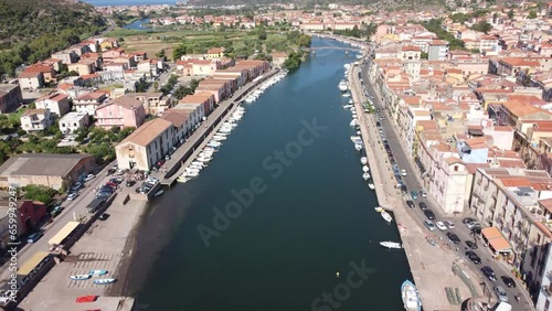 Drone view flying over the Temo river in Bosa moving from the Ponte Vecchio in the direction of Marina Bosa towards the Mediterranean Sea, on the island of Sardinia, Italy