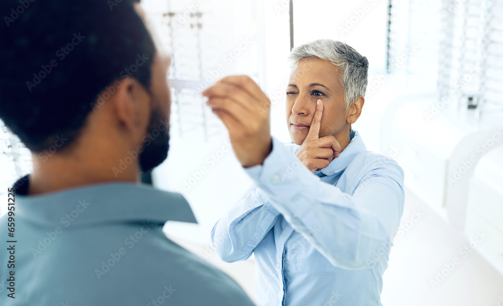 Obraz premium Vision, eyes and medical test with a man at the optometrist for prescription diagnosis or assessment. Distance, measure or exam with a customer talking to a consultant at the optician for assistanc