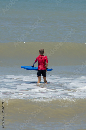boy with drill pole waiting for the wave on the beach