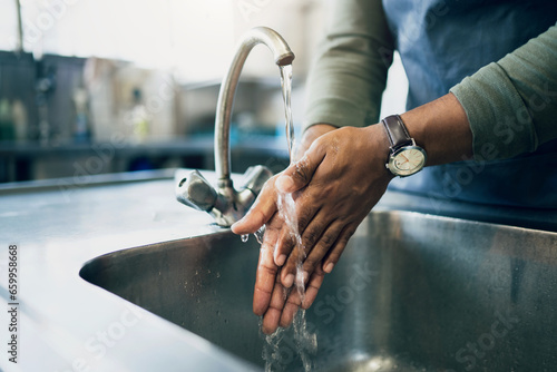 Water, hygiene and washing hands in the kitchen with a person by the sink for health or wellness. Cleaning, safety and bacteria with an adult closeup in the home to rinse for skin protection