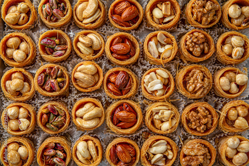 Bird's nest baklava with almonds, cashews, hazelnuts and pistachio. Turkish desert baklava with peanut for holiday or ramadan. Traditional Middle Eastern Flavors. Selective focus, pattern. Bird's nest baklava with almonds, cashews, hazelnuts and pistachio. Turkish desert baklava with peanut for holiday or ramadan. Traditional Middle Eastern Flavors. Selective focus, pattern.
