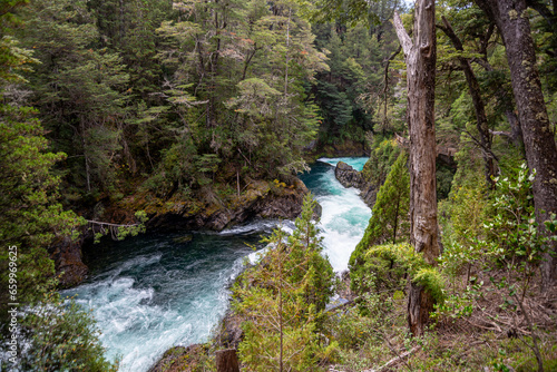 Top view of the Los Alerces waterfall surrounded by larches, Fitzroya cupressoides, and coihues, Nothofagus dombeyi, fed by the Manso River that flows into the Pacific Ocean, in Chile. photo