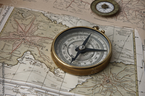 Travel, destination and history concept. Vintage compass placed on old and aged vintage map. Abstract background with copy space. Generative AI