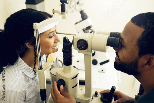 Eye test, machine and a woman with a doctor for optometry, vision problem and surgery on lens. Happy, clinic and a patient with a man or optometrist for a medical exam, retina health and check photo