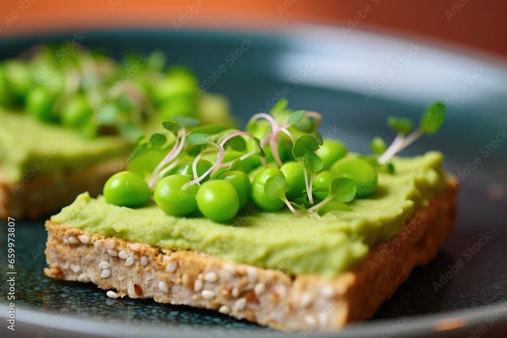 close-up of bread slice topped with mashed edamame on a ceramic dish close-up of bread slice topped with mashed edamame on a ceramic dish
