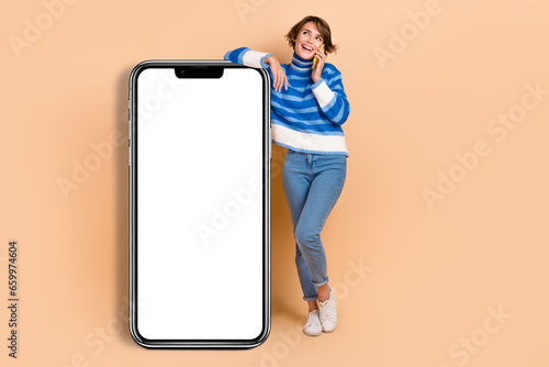 Full length photo of young girl conversation call phone near smartphone display application for communication isolated on beige color background