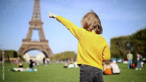 Adorable happy preschooler girl having fun near the Eiffel tower in Paris, France