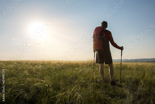 Hiker on the way. Man hiking at sunset. Man outdoor harmony with nature.