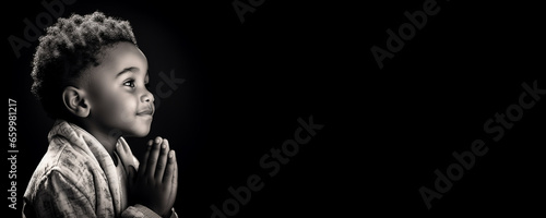 Black and white portrait banner of an African boy praying