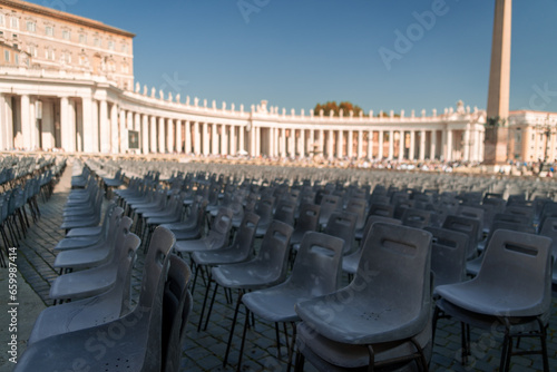 Photograph of auditorium with empty chairs. Mass in the Vatican. Saint Peter's Square. Event. Grouping of chairs. Concentration of people.