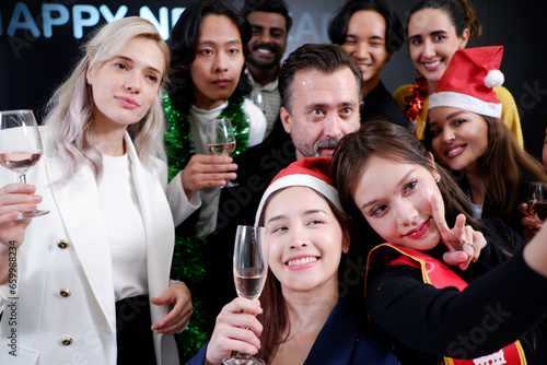 Group of men, young woman smiling, happy celebrating Christmas, drinking champagne, partying.
