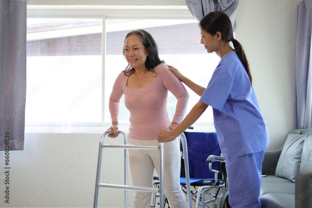 Female doctor help a senior patient who is doing physical therapy and is practicing walking with a walking stick.