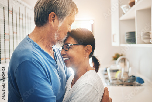 Hug, smile and mature couple kiss in home for care, support or trust together. Embrace, happy man and woman in kitchen for connection, romance or healthy relationship for love, commitment or marriage