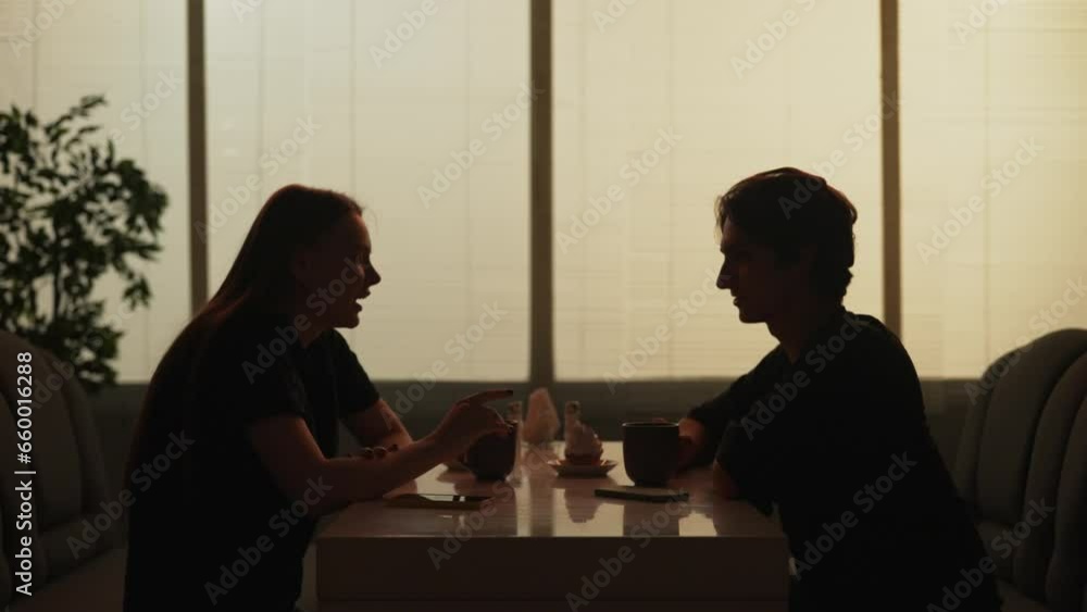 Man and woman sitting at the fast food bistro bar friendly talking, drinking coffee and eating cupcakes. Man and woman sitting at the fast food bistro bar friendly talking, drinking coffee and eating cupcakes.