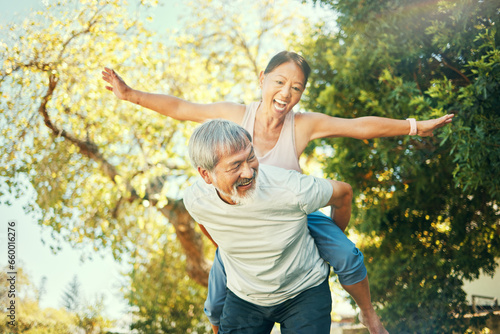 Couple, smile and piggyback in nature for fun, excited and playful in freedom, energy and joy. Happy elderly asian people, airplane and flying in summer, laugh and support for crazy in retirement
