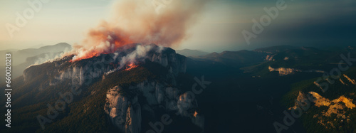fire on the top of a mountain captured by a drone, panoramic landscape banner 