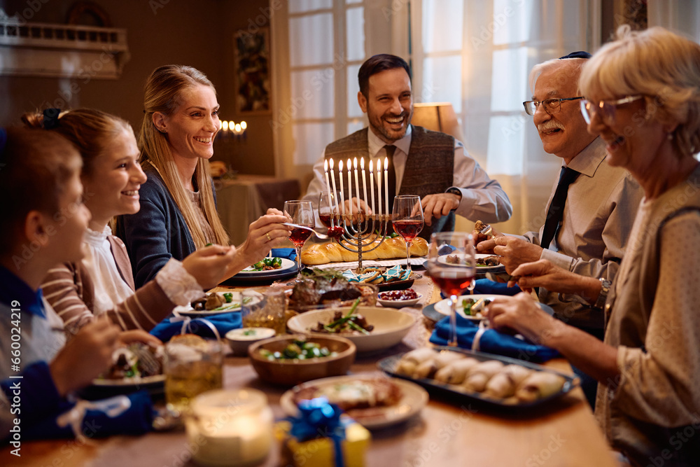 Happy Jewish extended family having meal at dining table on Hanukkah. - obrazy, fototapety, plakaty 