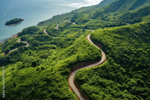 top view of countryside road passing through the green forrest and mountain