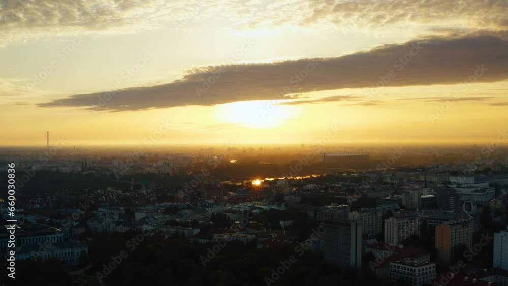 Establishing aerial panoramic view Warsaw city in Poland. Cinematic drone shot morning cityscape skyline, lot of buildings, orange morning sun on horizon, warm sunrise or sunset light Establishing aerial panoramic view Warsaw city in Poland. Cinematic drone shot morning cityscape skyline, lot of buildings, orange morning sun on horizon, warm sunrise or sunset light