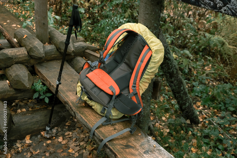 active lifestyle.Tourist backpack and hiking stick close-up on a wooden bench.Hiking in the mountains active lifestyle.Tourist backpack and hiking stick close-up on a wooden bench.Hiking in the mountains