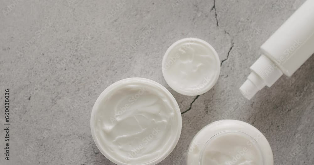 Top view on natural organic cream in jars and facial tonic for skincare ritual on tile background. Beauty and anti aging concept. Cosmetic products for healthy skin Top view on natural organic cream in jars and facial tonic for skincare ritual on tile background. Beauty and anti aging concept. Cosmetic products for healthy skin