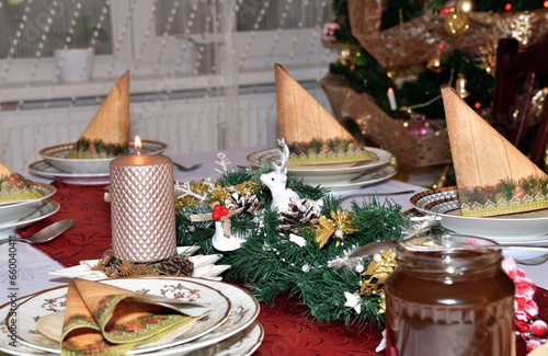 Obraz na płótnie Lighting a Christmas candle on the Christmas table w salonie