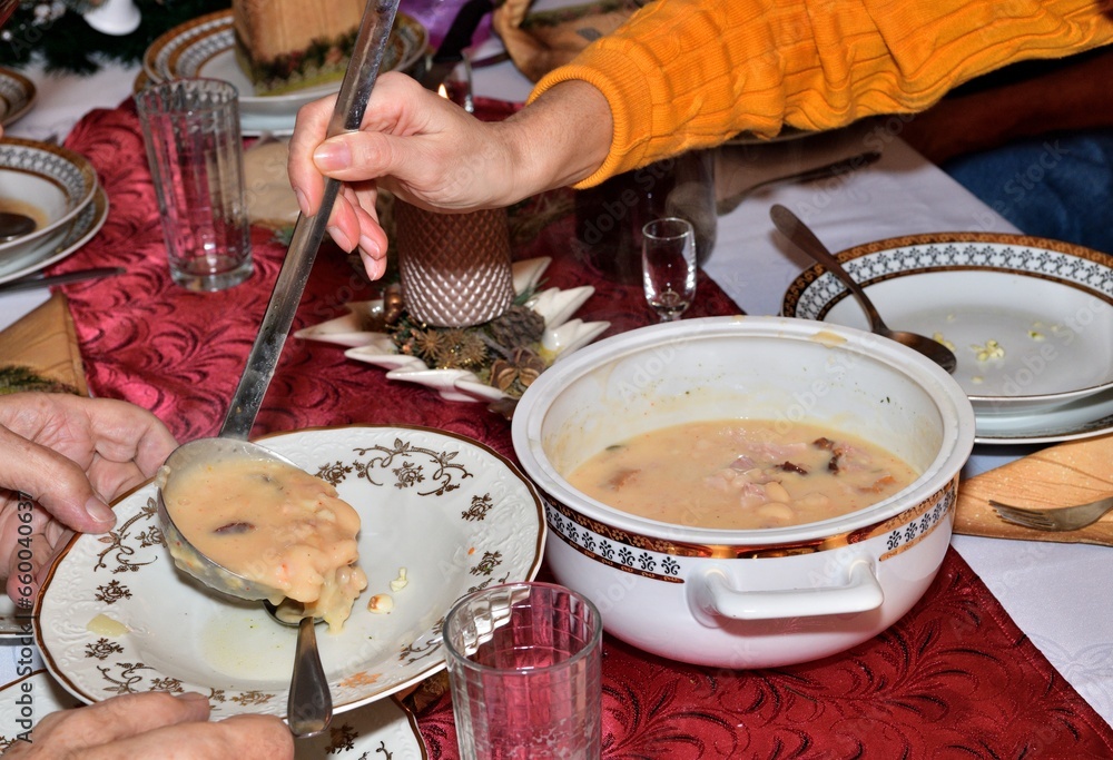 Scooping Christmas bean soup into a plate during the Christmas holidays