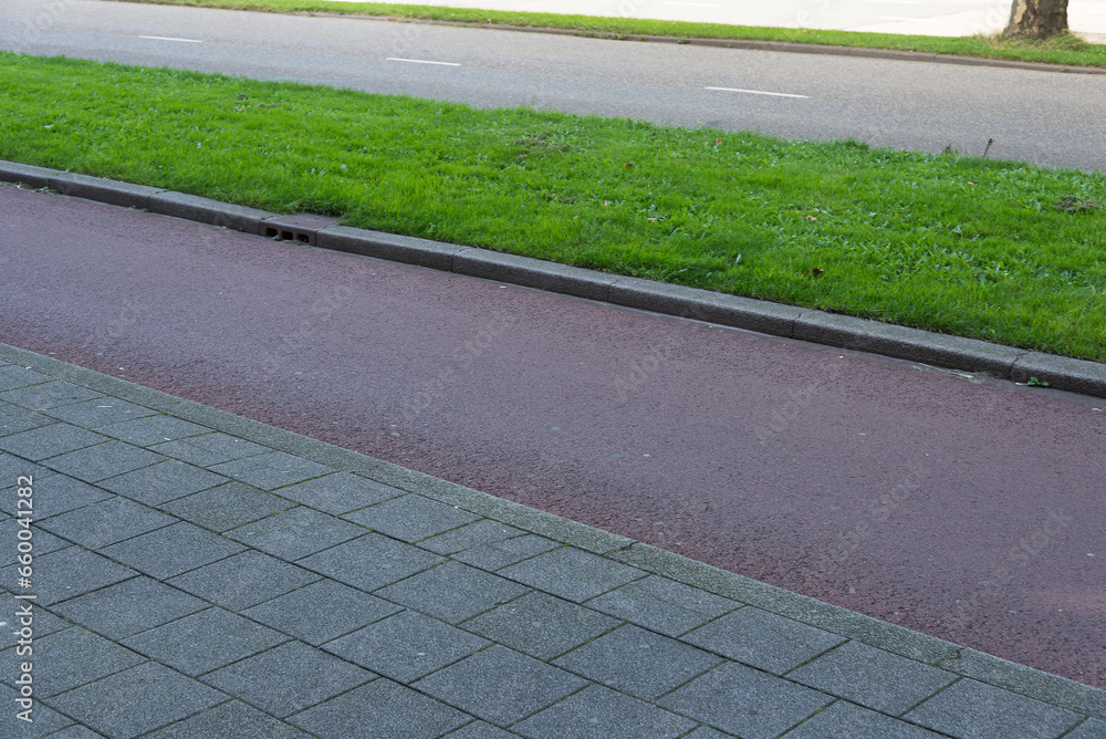 Obraz premium Ecological infrastructure. Sidewalk next to bicycle lane next to green strip and car road