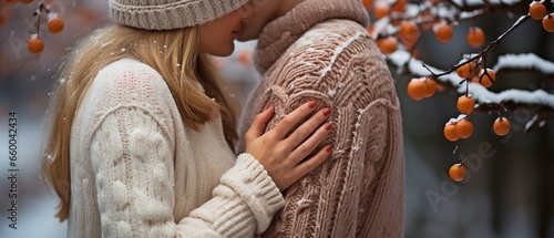 young couple in closeup holding hands while sporting adorable knit mittens in the winter. photo