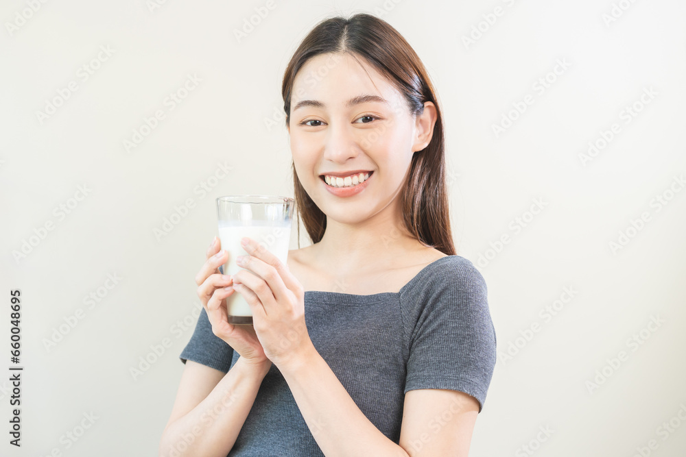 Happy, asian young woman, girl drinking a glass of white fresh, warm or hot dairy milk for calcium, vitamin wholesome good nutrition in morning. lifestyle, product healthy people, Isolated background. Happy, asian young woman, girl drinking a glass of white fresh, warm or hot dairy milk for calcium, vitamin wholesome good nutrition in morning. lifestyle, product healthy people, Isolated background.