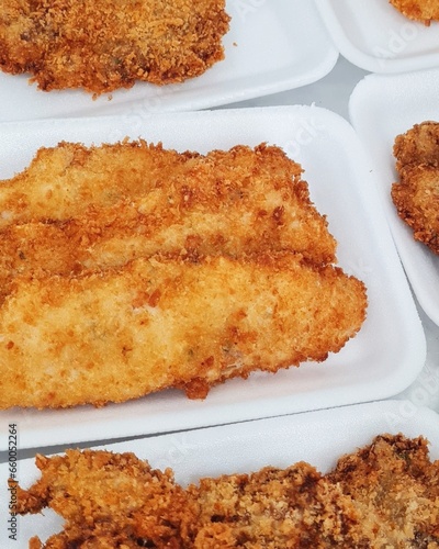 Breaded white hake fillet (Cynoscion leiarchus) in Styrofoam packaging for sale.