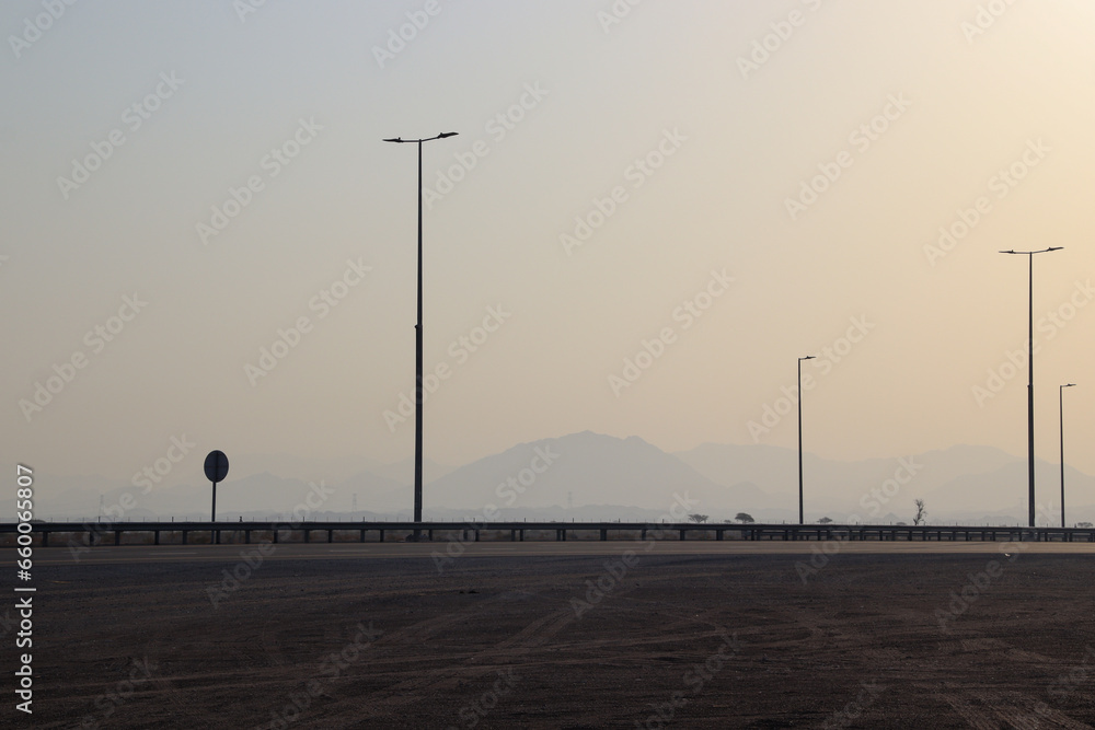 Streetlights in a highway of dubai with mountains on background