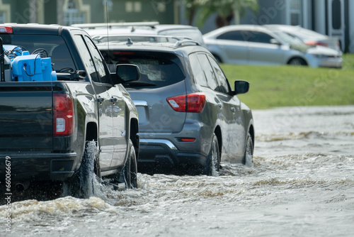 Fotografia Hurricahe rainfall flooded Florida road with evacuating cars and surrounded with