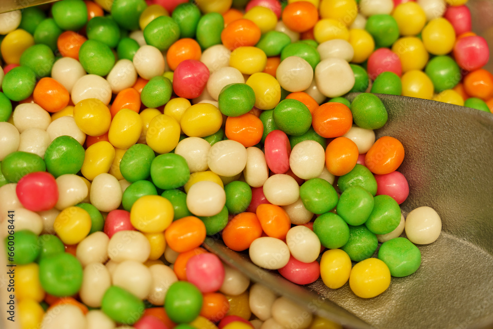 Obraz premium There are candies on the counter - peanuts in multi-colored glaze and a scoop.