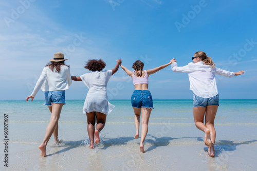 Happy children laughing and enjoying at beach. Teenage playing with friends at the sea. Vacations time and friendship concept.
