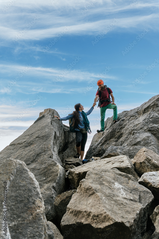 Climbers high-five each other at the top of the mountain.