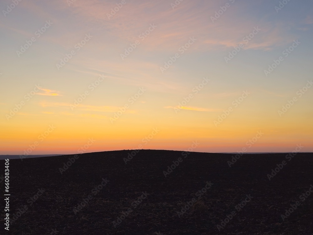 Obraz premium A sunset over a field
